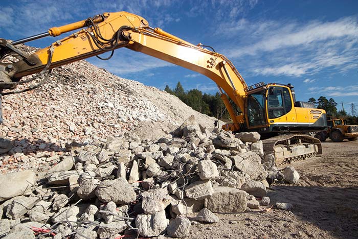 Excavator clearing concrete