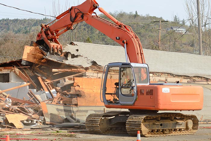 excavator tearing down building